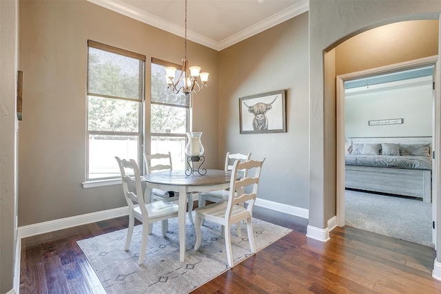 9001 Magnolia Vale Dr, Granbury, TX 76049 - dining room featuring wood finished floors, ornamental molding, arched walkways, baseboards, and a chandelier