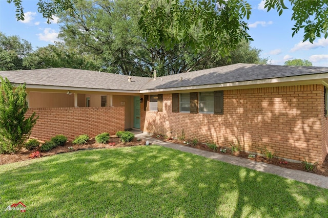 ranch-style house featuring brick siding, a front yard, and a shingled roof