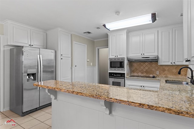 kitchen featuring stainless steel appliances, a sink, white cabinets, light stone countertops, and ornamental molding