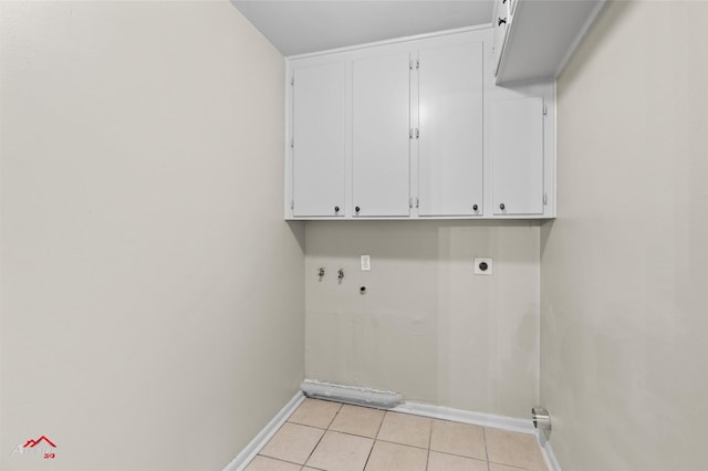 clothes washing area featuring cabinet space, baseboards, electric dryer hookup, light tile patterned floors, and washer hookup