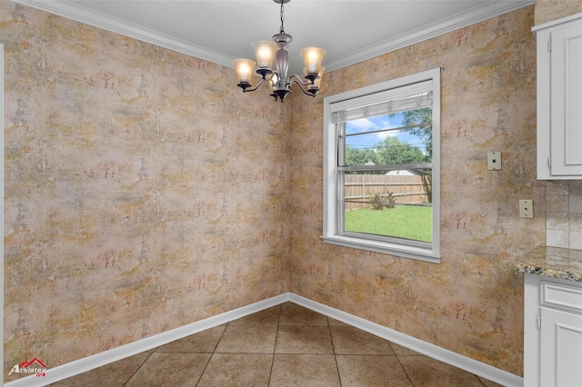 unfurnished dining area with a chandelier, baseboards, crown molding, and tile patterned flooring