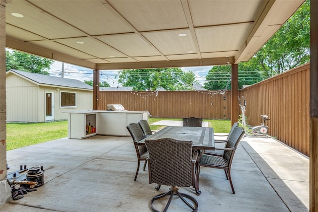 2902 Hillglenn Rd, Dallas, TX 75228 - view of patio with a fenced backyard, an outdoor kitchen, outdoor dining space, and an outbuilding