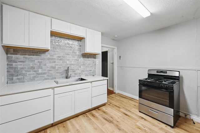 4808 Birchman Ave, Fort Worth, TX 76107 - kitchen with stainless steel gas range oven, a sink, white cabinets, light countertops, and a textured ceiling