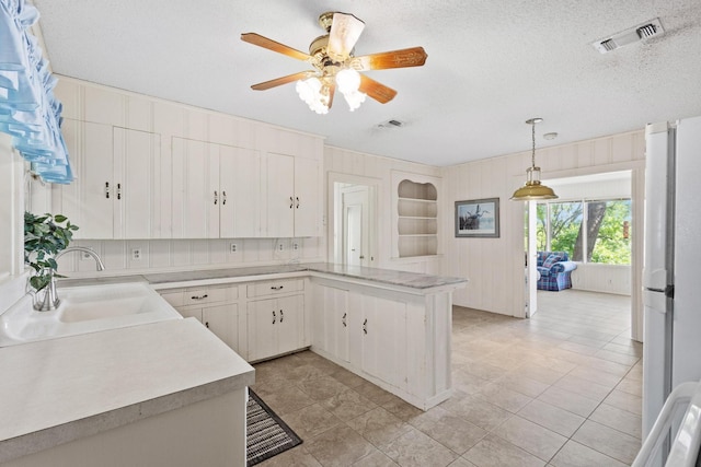 219 Ray Rd, Pottsboro, TX 75076 - kitchen with a sink, light countertops, a peninsula, a ceiling fan, and pendant lighting
