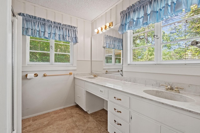 219 Ray Rd, Pottsboro, TX 75076 - full bath featuring a textured ceiling, double vanity, and baseboards