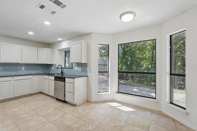 521 Bent Creek Dr, Garland, TX 75040 - kitchen featuring dishwasher, healthy amount of natural light, tasteful backsplash, dark countertops, and a textured ceiling