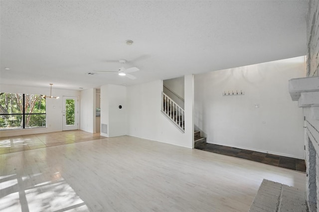 521 Bent Creek Dr, Garland, TX 75040 - unfurnished living room featuring wood finished floors, stairway, a fireplace, and ceiling fan