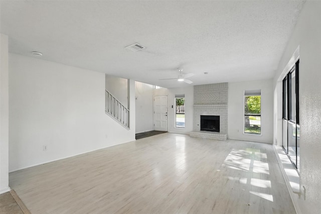 521 Bent Creek Dr, Garland, TX 75040 - unfurnished living room with a ceiling fan, wood finished floors, stairway, a fireplace, and baseboards