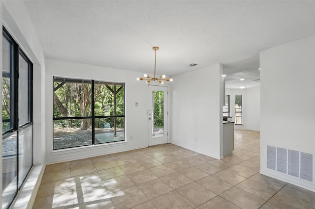 521 Bent Creek Dr, Garland, TX 75040 - empty room with plenty of natural light, light tile patterned floors, and a chandelier