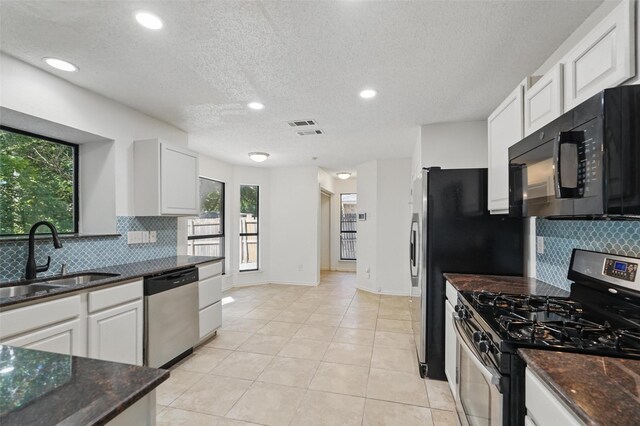 521 Bent Creek Dr, Garland, TX 75040 - kitchen with appliances with stainless steel finishes, a sink, decorative backsplash, white cabinetry, and recessed lighting