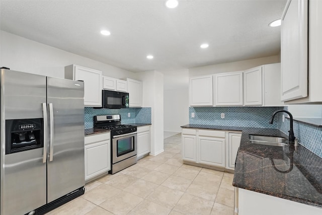 521 Bent Creek Dr, Garland, TX 75040 - kitchen featuring appliances with stainless steel finishes, a sink, decorative backsplash, white cabinetry, and dark stone countertops