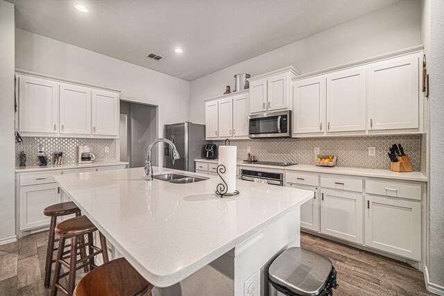 6505 Boot Jack Dr, Burleson, TX 76058 - kitchen featuring appliances with stainless steel finishes, a sink, a kitchen breakfast bar, backsplash, and a center island with sink