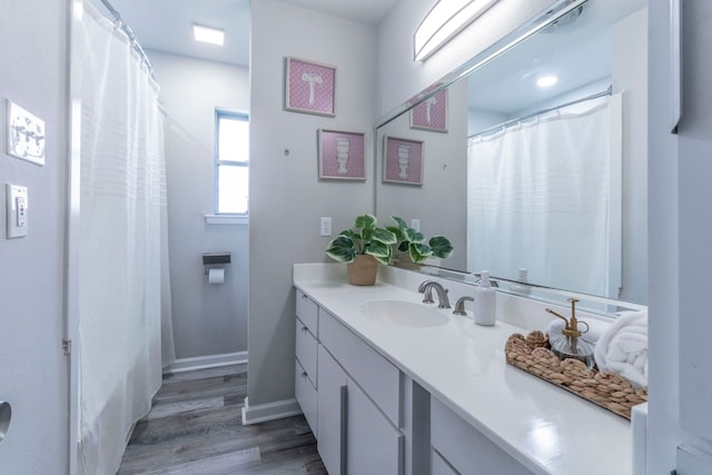 2801 Peachtree Ln, Pantego, TX 76013 - full bathroom featuring wood finished floors, vanity, baseboards, and curtained shower