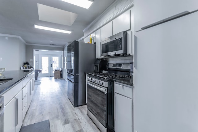 2801 Peachtree Ln, Pantego, TX 76013 - kitchen with stainless steel appliances, crown molding, french doors, white cabinetry, and light wood-style flooring