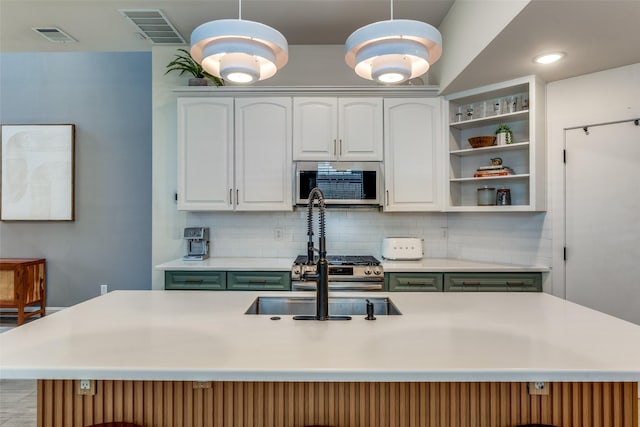 5006 Mission Ave, Dallas, TX 75206 - kitchen with stainless steel microwave, green cabinetry, light countertops, and backsplash