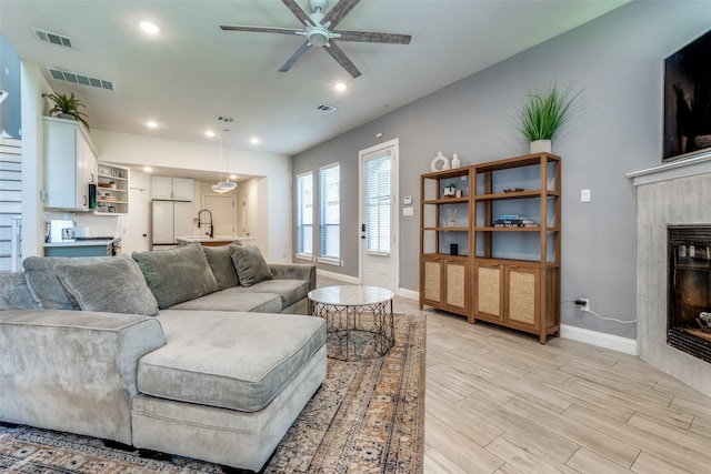 5006 Mission Ave, Dallas, TX 75206 - living area with baseboards, a ceiling fan, a tile fireplace, light wood-style flooring, and recessed lighting