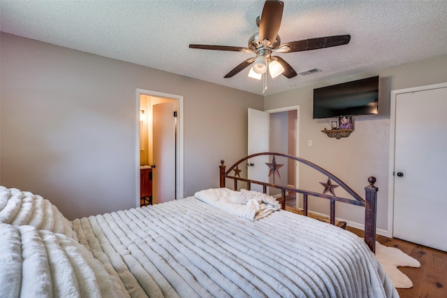 bedroom with a textured ceiling, ceiling fan, and wood finished floors