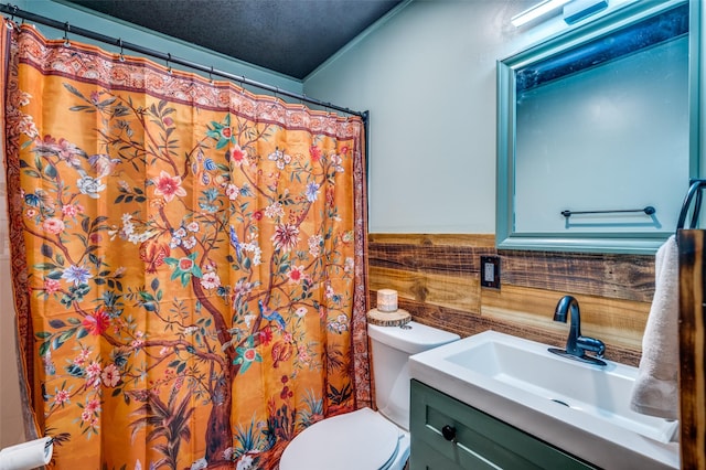bathroom with toilet, wainscoting, vanity, and a shower with shower curtain