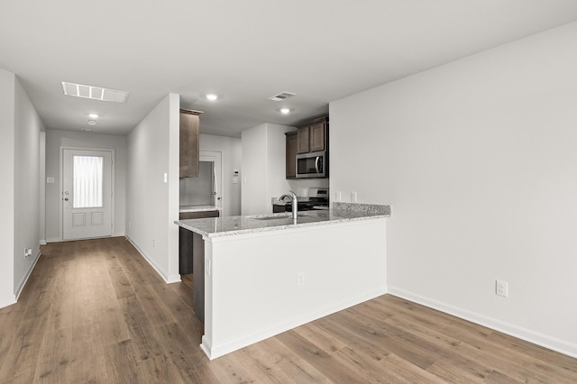 432 Gib Woodall Dr, Venus, TX 76084 - kitchen featuring stainless steel appliances, wood finished floors, dark brown cabinetry, baseboards, and recessed lighting