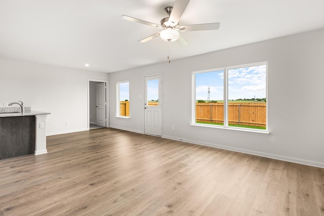 432 Gib Woodall Dr, Venus, TX 76084 - unfurnished living room featuring wood finished floors, baseboards, a ceiling fan, a sink, and recessed lighting