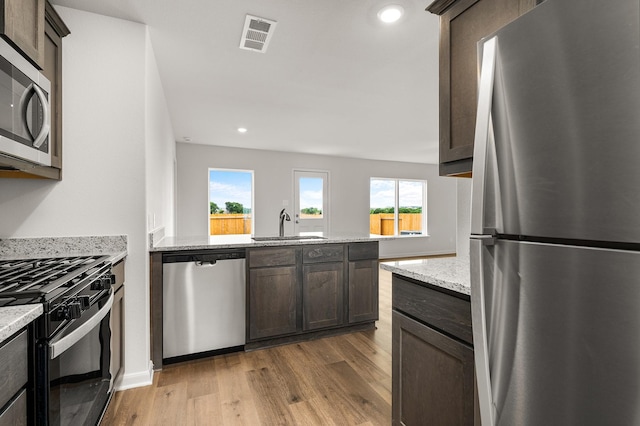 432 Gib Woodall Dr, Venus, TX 76084 - kitchen with appliances with stainless steel finishes, wood finished floors, a sink, a peninsula, and recessed lighting