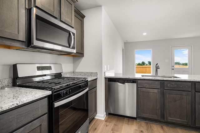 432 Gib Woodall Dr, Venus, TX 76084 - kitchen featuring appliances with stainless steel finishes, a sink, dark brown cabinetry, light wood finished floors, and recessed lighting
