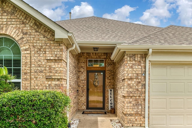 203 Millington Trl, Mansfield, TX 76063 - view of exterior entry with a shingled roof, brick siding, and an attached garage