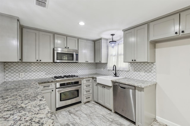 7613 Hewitt St, North Richland Hills, TX 76182 - kitchen with stainless steel appliances, gray cabinets, a sink, light stone countertops, and decorative backsplash