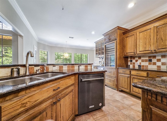 2215 Firestone Cir, Tyler, TX 75703 - kitchen with dishwashing machine, brown cabinetry, a sink, backsplash, and dark stone counters