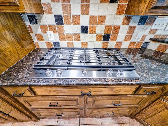 2215 Firestone Cir, Tyler, TX 75703 - kitchen view of stainless steel gas stovetop, backsplash, and dark stone counters