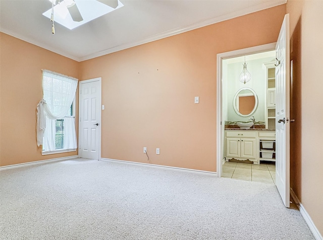 2215 Firestone Cir, Tyler, TX 75703 - empty room with light colored carpet, a skylight, baseboards, a ceiling fan, and crown molding