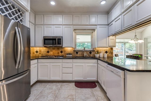 605 Keel Way, Azle, TX 76020 - kitchen featuring stainless steel appliances, a sink, light tile patterned flooring, white cabinets, and decorative backsplash