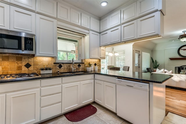 605 Keel Way, Azle, TX 76020 - kitchen with appliances with stainless steel finishes, a sink, open floor plan, a peninsula, and light tile patterned floors