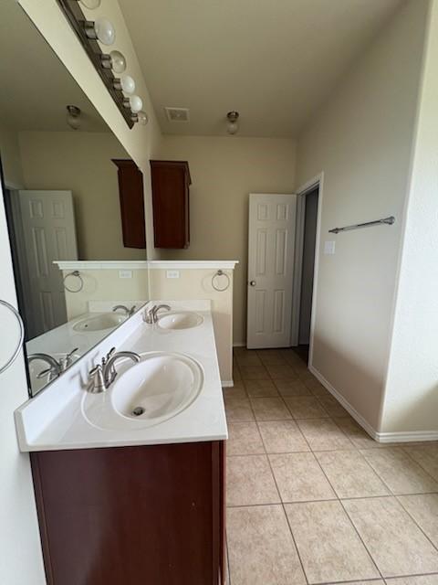 10237 Marigold Rd, Waco, TX 76708 - bathroom with tile patterned flooring, baseboards, and double vanity