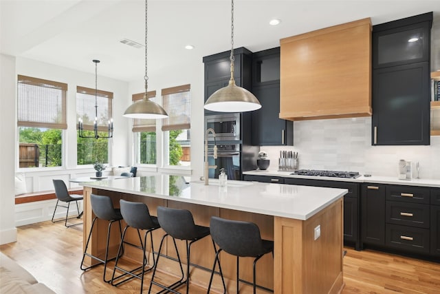 kitchen featuring a sink, appliances with stainless steel finishes, light countertops, and light wood-type flooring