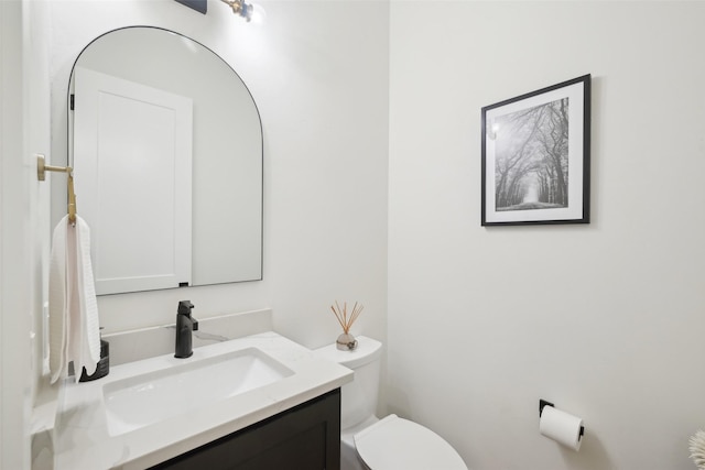 half bath featuring toilet and vanity