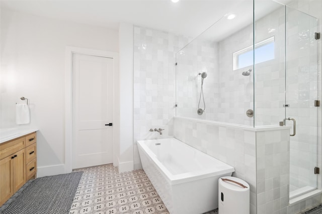 bathroom featuring a tub, tile patterned floors, a shower stall, vanity, and baseboards