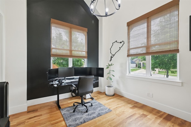 office area with a chandelier, plenty of natural light, baseboards, and wood finished floors