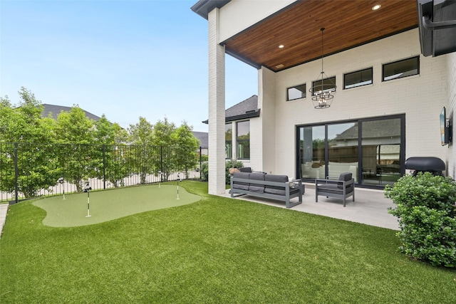 rear view of property featuring an area to practice putting, a patio area, brick siding, an outdoor living space, and fence