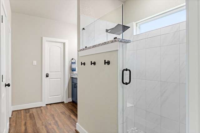 2610 Austin Dr, Granbury, TX 76048 - bathroom featuring walk in shower, wood finished floors, vanity, and baseboards