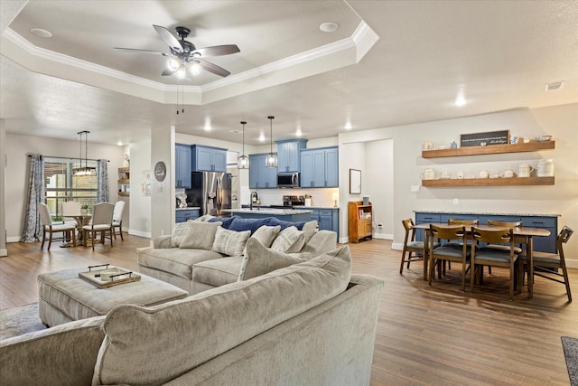 2610 Austin Dr, Granbury, TX 76048 - living area featuring a tray ceiling, a ceiling fan, crown molding, wood finished floors, and baseboards