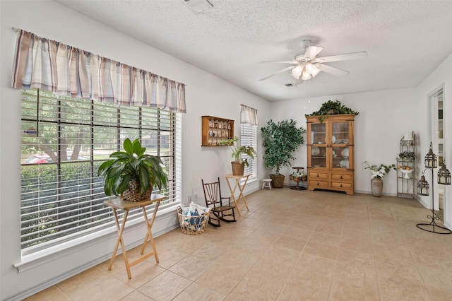 805 Sandpiper Dr, Denton, TX 76205 - living area featuring a ceiling fan, a textured ceiling, and light tile patterned floors
