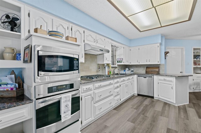 805 Sandpiper Dr, Denton, TX 76205 - kitchen featuring appliances with stainless steel finishes, white cabinets, a peninsula, and light wood-type flooring