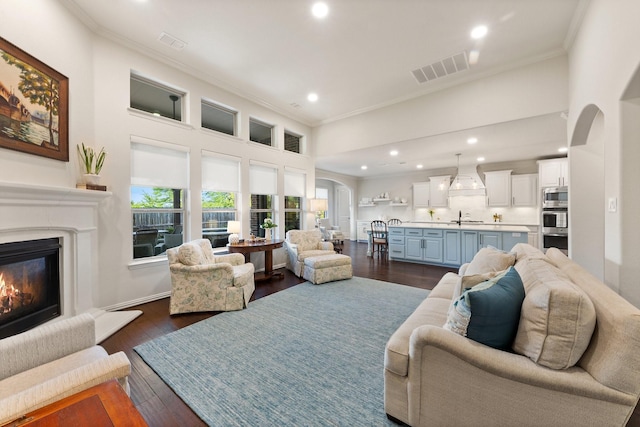 14322 Summerwoods Ln, Frisco, TX 75035 - living room with ornamental molding, arched walkways, plenty of natural light, a glass covered fireplace, and recessed lighting