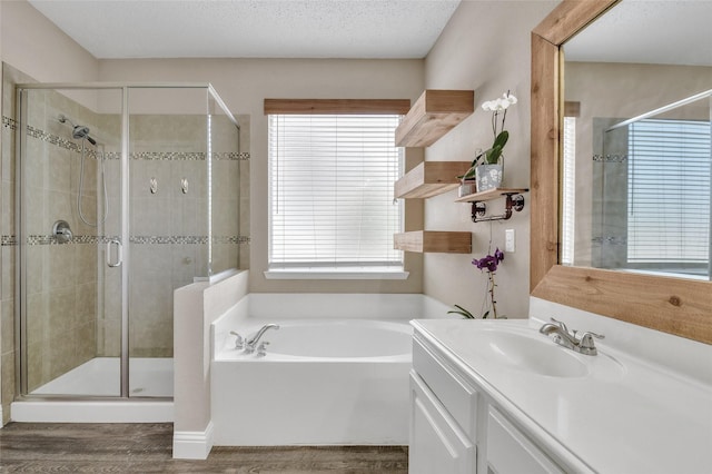 207 Trailwood Dr, Allen, TX 75002 - bathroom featuring wood finished floors, a stall shower, a garden tub, and vanity