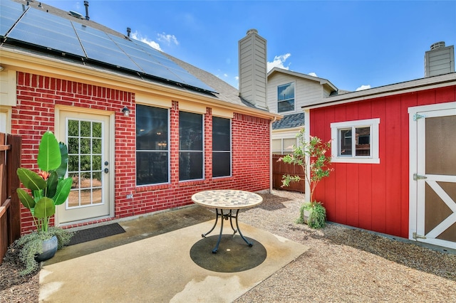 207 Trailwood Dr, Allen, TX 75002 - back of house with a patio, brick siding, solar panels, and an outbuilding