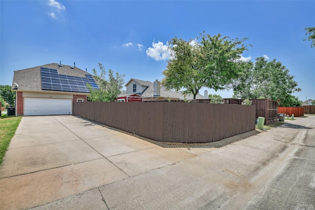 207 Trailwood Dr, Allen, TX 75002 - view of side of home featuring brick siding, concrete driveway, fence, an attached garage, and a shingled roof