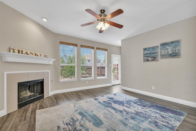 207 Trailwood Dr, Allen, TX 75002 - unfurnished living room featuring wood finished floors, ceiling fan, a tile fireplace, and baseboards