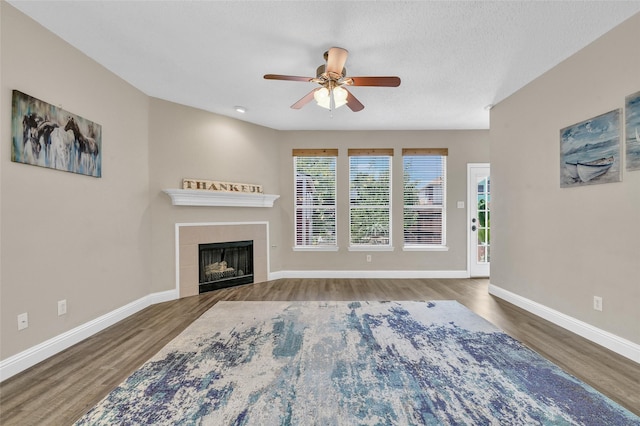 207 Trailwood Dr, Allen, TX 75002 - unfurnished living room featuring wood finished floors, plenty of natural light, a ceiling fan, and a tile fireplace