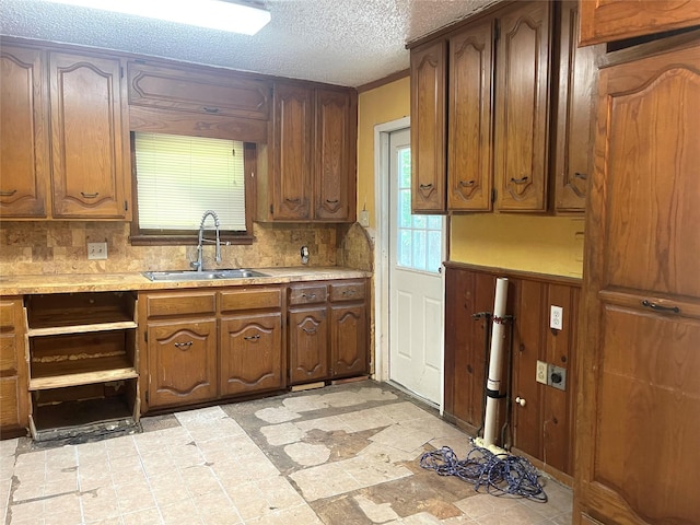 6645 Onyx Dr N, North Richland Hills, TX 76180 - kitchen featuring a sink, light countertops, tasteful backsplash, and a textured ceiling